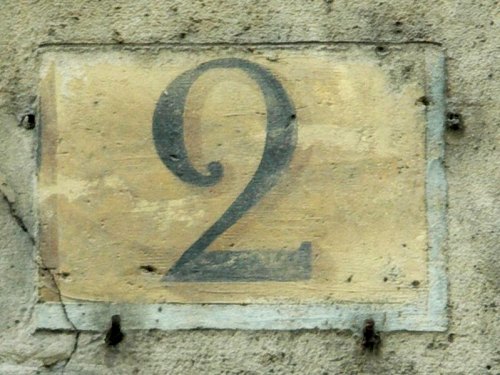 Numéro conforme à la réglementation de 1805 (chiffre noir sur fond ocre dans une rue perpendiculaire à la Seine)